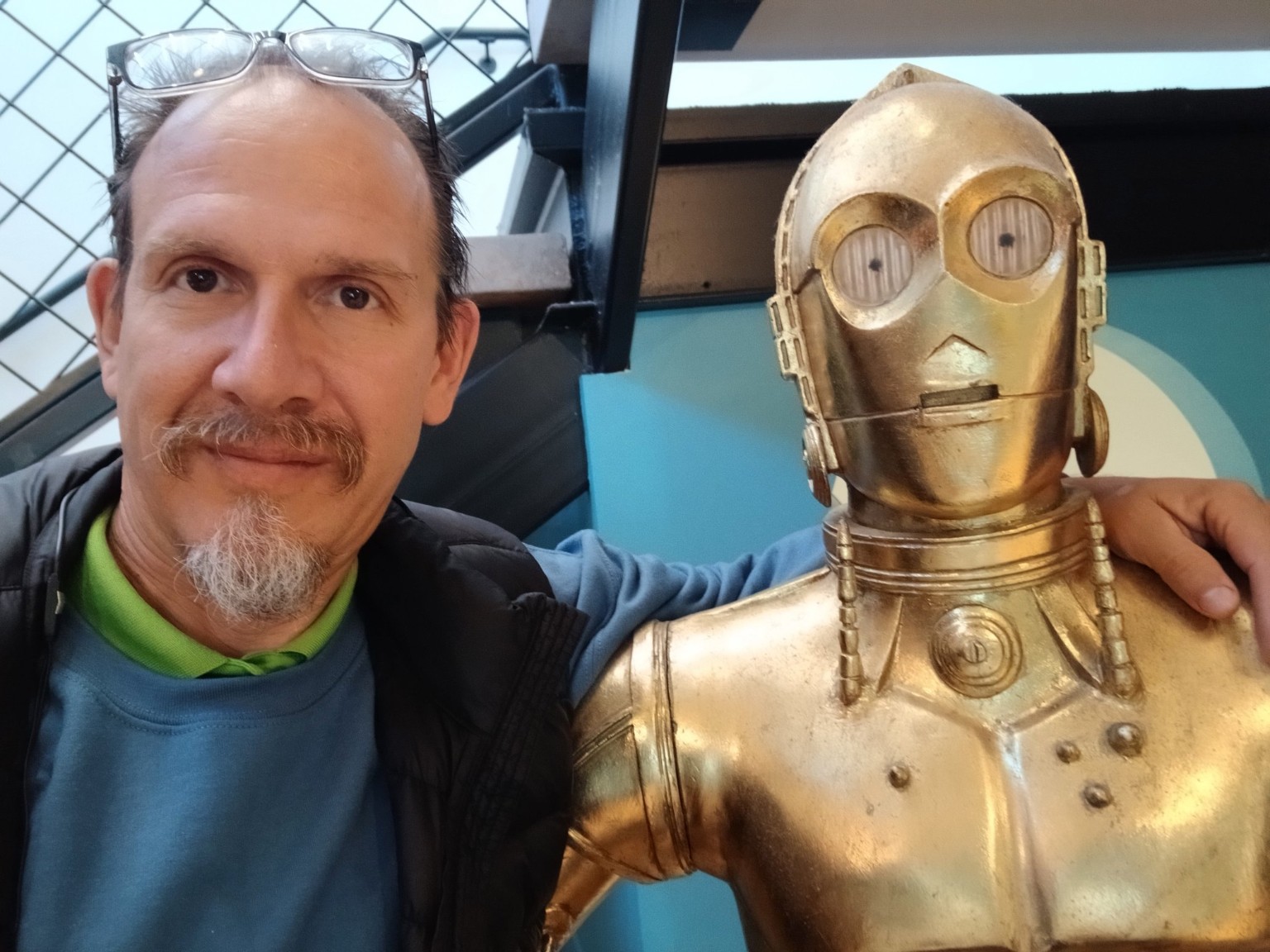 A playful photo of the site owner beside a gold humanoid robot figure.